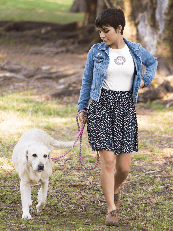 woman walking dog wearing white womens tshirt with vintage graphic logo in circle of palm tree brand gin