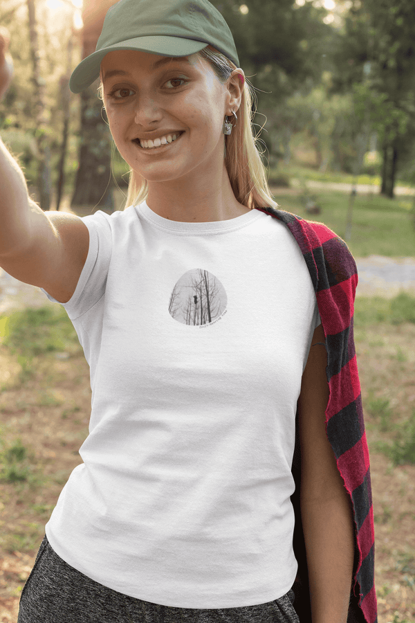 woman wearing white t-shirt with vintage photo print of bear cub in a tree and the text fruit-bearing tree