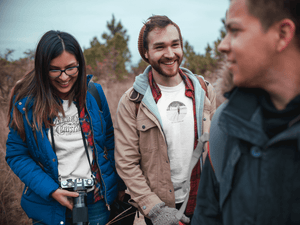 two men and one woman with a camera wearing white tshirts with vintage photo prints