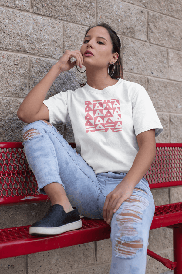 woman sitting on red bench wearing white unisex tshirt with faded red traingles and dots artistic print