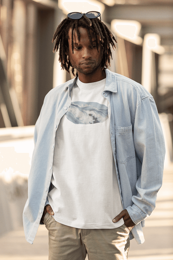 man wearing white unisex tshirt with vintage graphic woodblock print of ocean waves in light aquamarine color